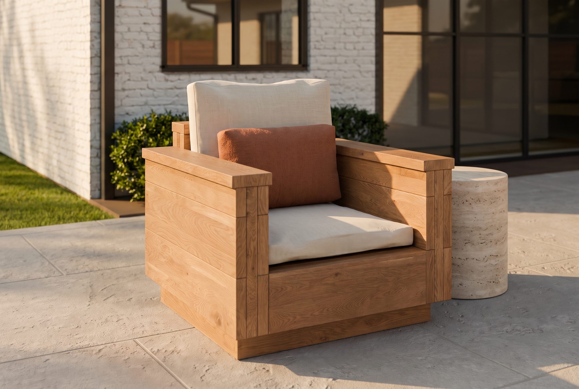 The Block Lounge Chair in honey-oiled cedar with linen cushions on a backyard patio